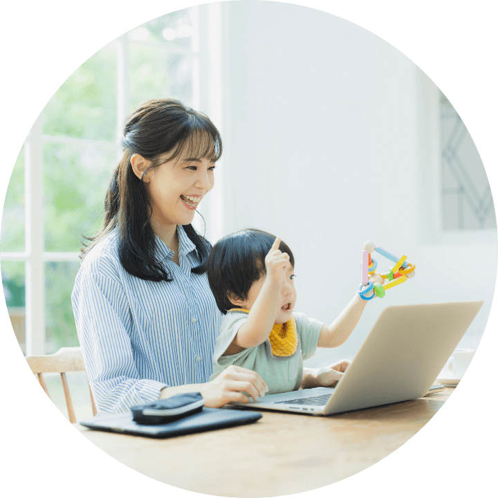 女性が子供とリビングでノートパソコンを操作する様子